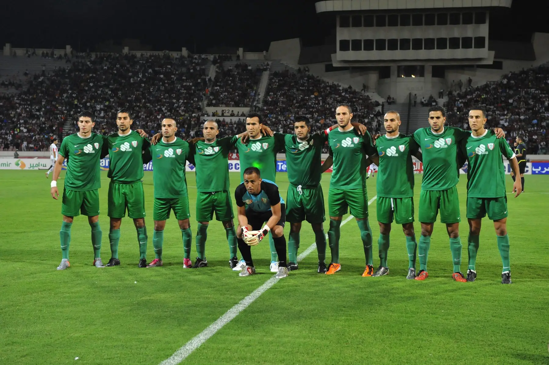 L’équipe de l’IZK, en vert, avant Wydad-IZK (2-0), au complexe Mohammed-V, le 20 août 2011 : premier match de D1 après la remontée. Photo : Mustapha Ennaimi, CC BY 2.0