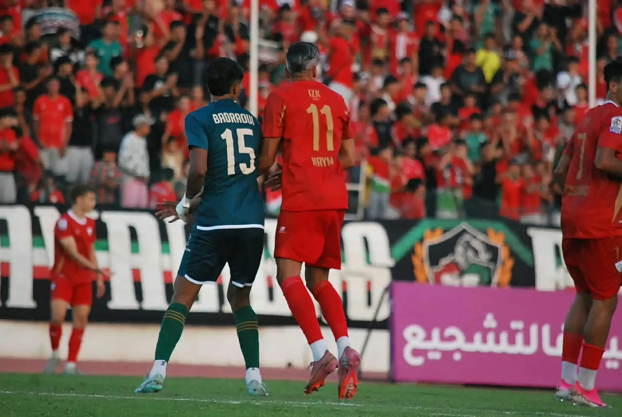 Younes Naiym, numéro 11, au duel avec un défenseur de l’Olympique Khouribga devant les supporters